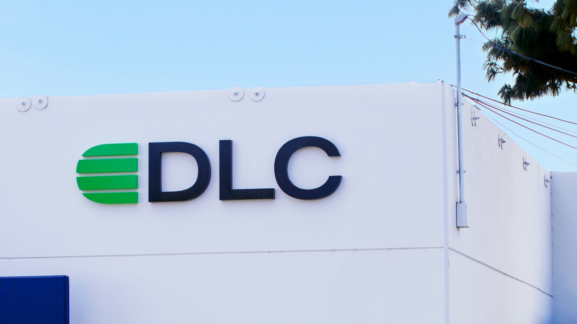 DLC logo on a white background with a clear blue sky
